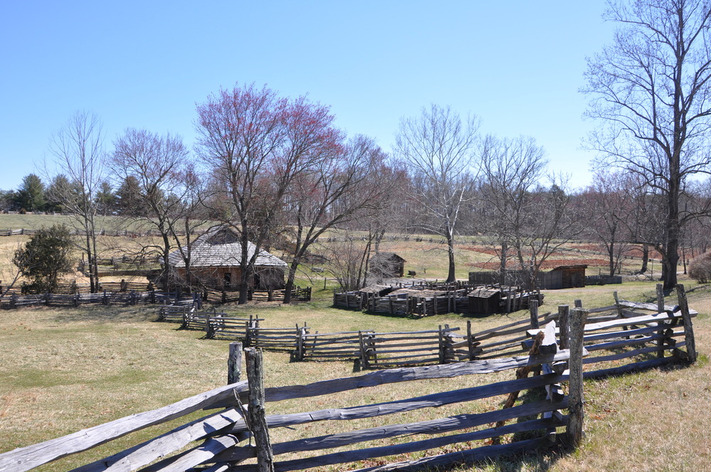 A farm with buildings and wooden fences on an early winter day.