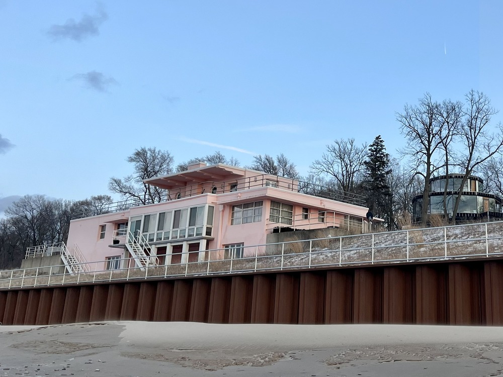 Historic multi-story pink house above a beach